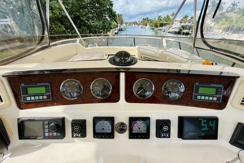 Rogue One Yacht Photos Pics 2003 Sea Ray 560 Sedan Bridge helm with gauges and navigation controls.