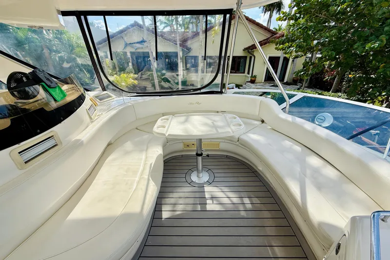 Rogue One Yacht Photos Pics 2003 Sea Ray 560 Sedan Bridge interior with curved seating and table, surrounded by windows.