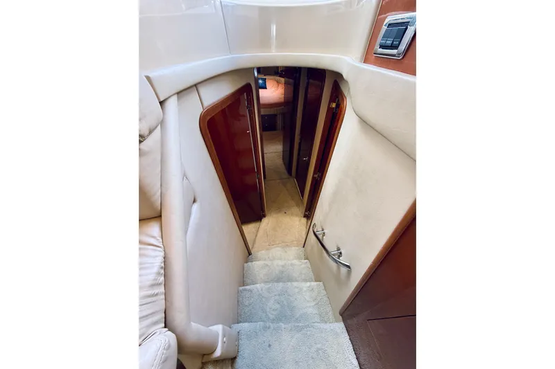 Rogue One Yacht Photos Pics Interior staircase of 2003 Sea Ray 560 Sedan Bridge yacht, featuring plush carpeting and wooden accents.