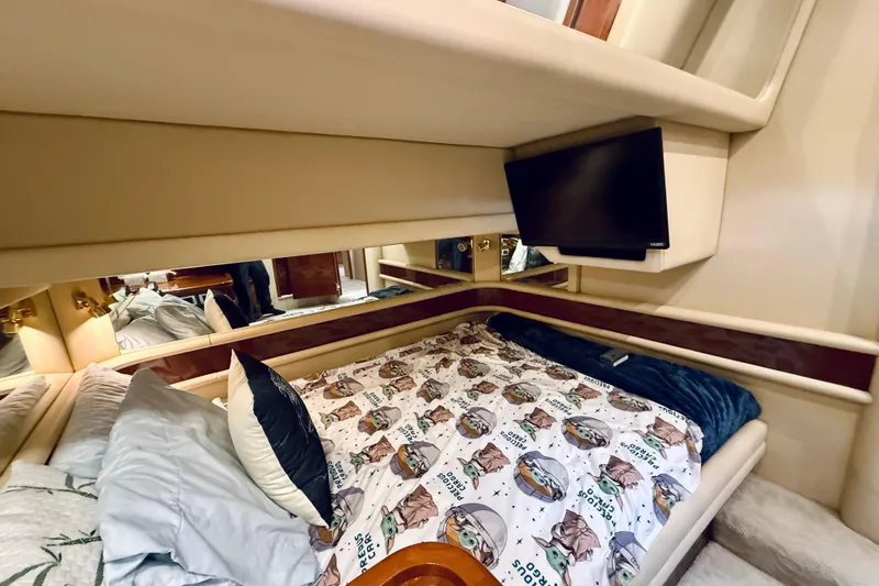 Rogue One Yacht Photos Pics Cozy bedroom in 2003 Sea Ray 560 Sedan Bridge with TV and themed bedding.