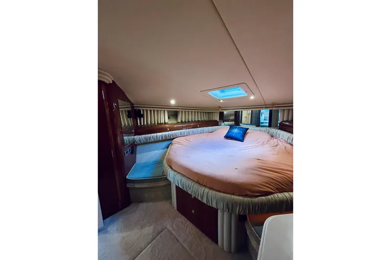 Rogue One Yacht Photos Pics Luxurious 2003 Sea Ray 560 Sedan Bridge bedroom with plush bedding and elegant decor.