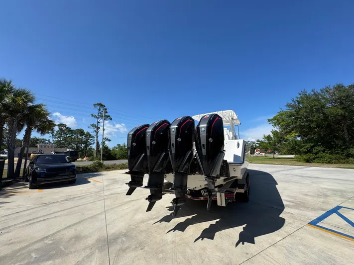  Yacht Photos Pics 2020 Invincible 39 Open Fisherman boat with four powerful outboard engines in a sunny parking lot.