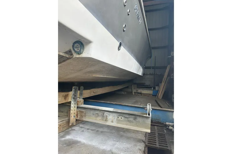  Yacht Photos Pics 2020 Pursuit OS 325 Offshore boat in storage, showing hull and support structure.