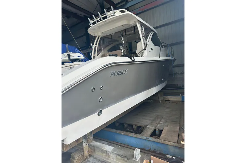  Yacht Photos Pics 2020 Pursuit OS 325 Offshore boat in storage, showcasing sleek design and modern features.