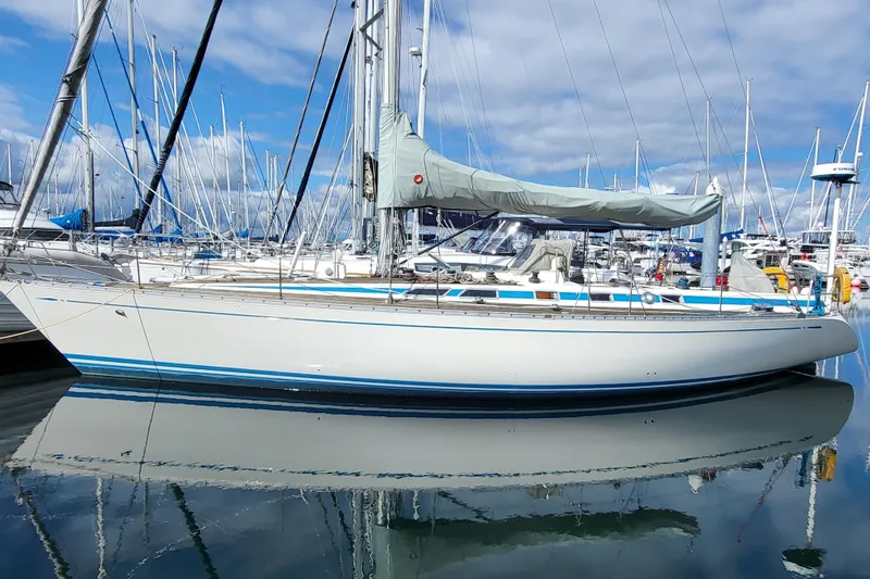 Name Reserved Yacht Photos Pics 1985 Nautor Swan 46 sailboat docked in a marina, reflecting on calm water.