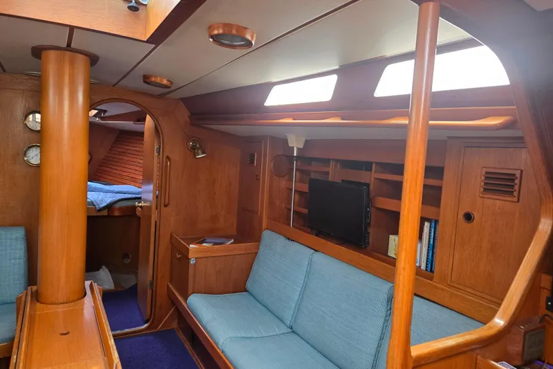Name Reserved Yacht Photos Pics Interior of 1985 Swan 46 yacht with wooden finish and blue seating.
