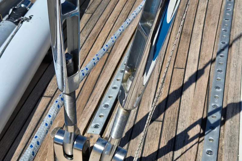 Name Reserved Yacht Photos Pics Close-up of 1985 Swan 46 yacht deck with polished metal fittings and wooden planks.