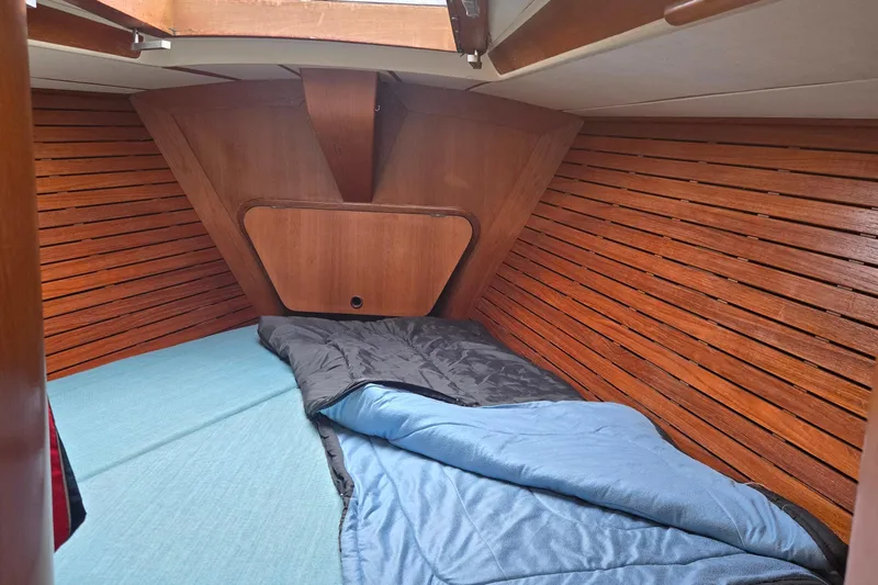 Name Reserved Yacht Photos Pics Cozy cabin interior of 1985 Swan 46 yacht with wooden paneling and bedding.