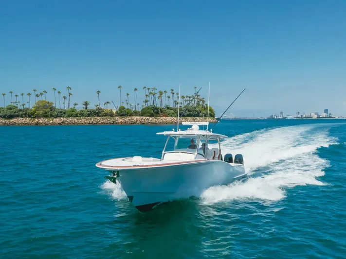  Yacht Photos Pics 2026 Mag Bay 43 Center Console cruising on blue ocean near palm-lined shore.