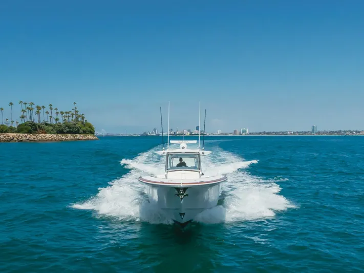  Yacht Photos Pics 2026 Mag Bay 43 Center Console cruising on blue ocean near city skyline.
