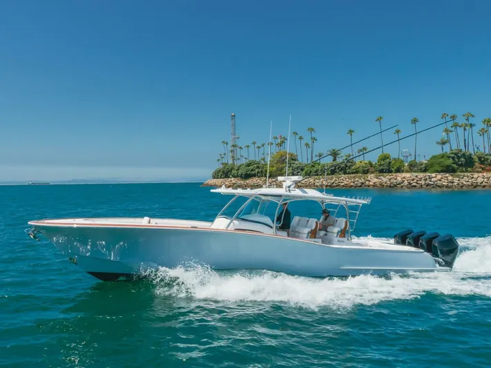 Yacht Photos Pics 2026 Mag Bay 43 Center Console cruising on blue ocean near palm-lined shore.