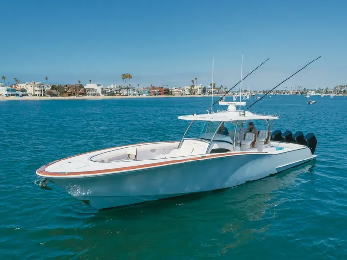  Yacht Photos Pics 2026 Mag Bay 43 Center Console boat on clear blue water near coastal homes.