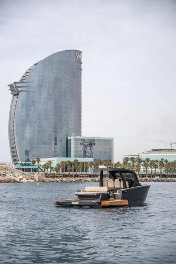 Maxim Yachts | Max43 Comfort Yacht Photos Pics 2025 Maxim Yachts 43 in harbor, modern architecture in background.