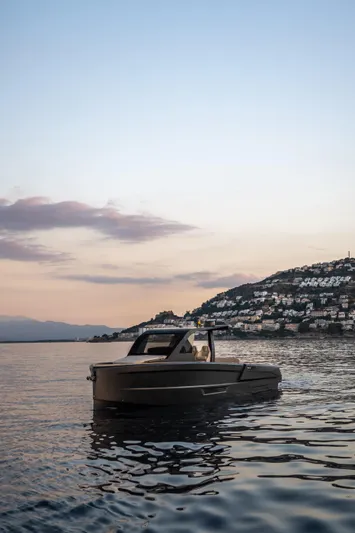 Maxim Yachts | Max43 Comfort Yacht Photos Pics 2025 Maxim Yachts 43 cruising at sunset near a coastal hillside.