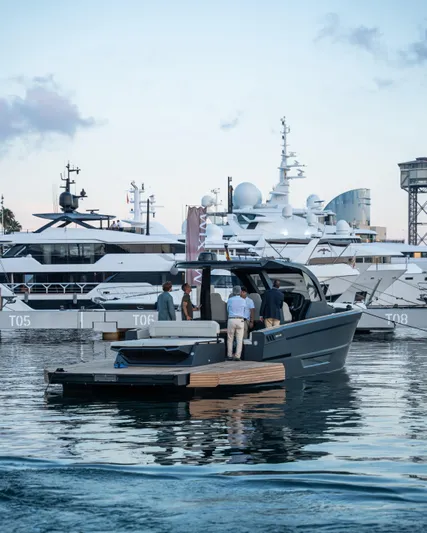 Maxim Yachts | Max43 Comfort Yacht Photos Pics 2025 Maxim Yachts 43 in marina, people onboard, surrounded by luxury boats.