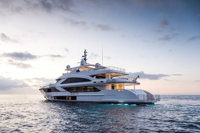 Checked Out Yacht Photos Pics Luxury Majesty 140 yacht on serene ocean at sunset, 2020 model.