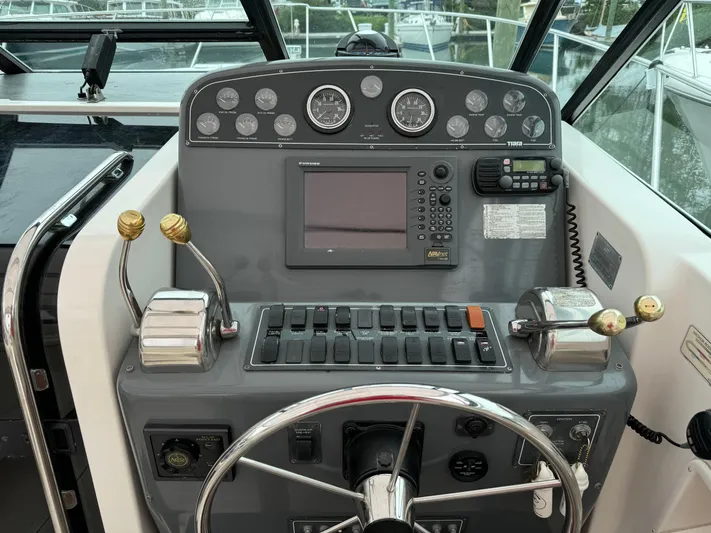 Vixen Yacht Photos Pics Control panel of a 2002 Tiara Yachts 3500 Express boat with steering wheel and navigation instruments.