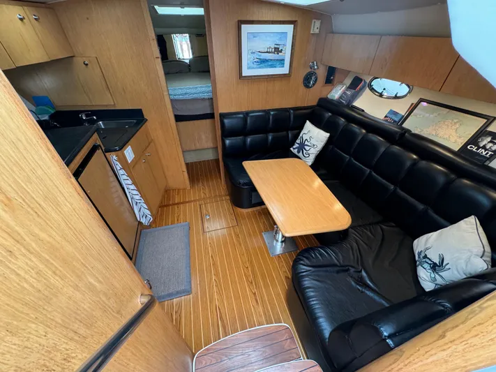 Vixen Yacht Photos Pics 2002 Tiara Yachts 3500 Express interior with black leather seating and wooden finishes.