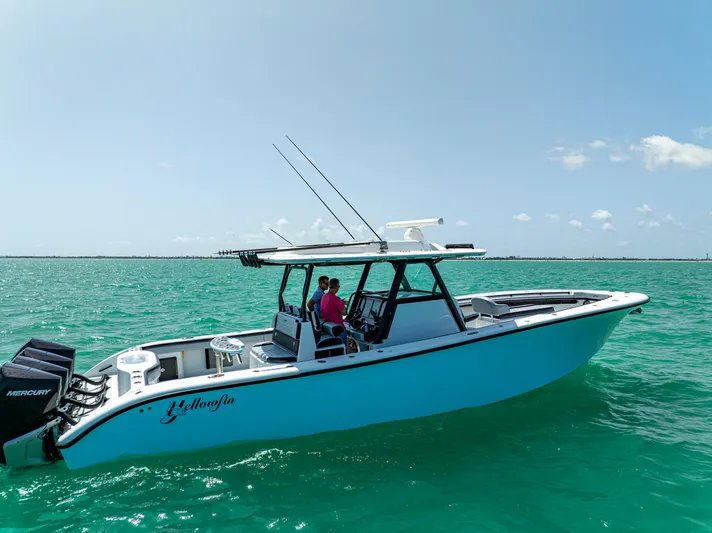  Yacht Photos Pics 2022 Yellowfin 39 boat on turquoise water, clear sky, two people onboard.
