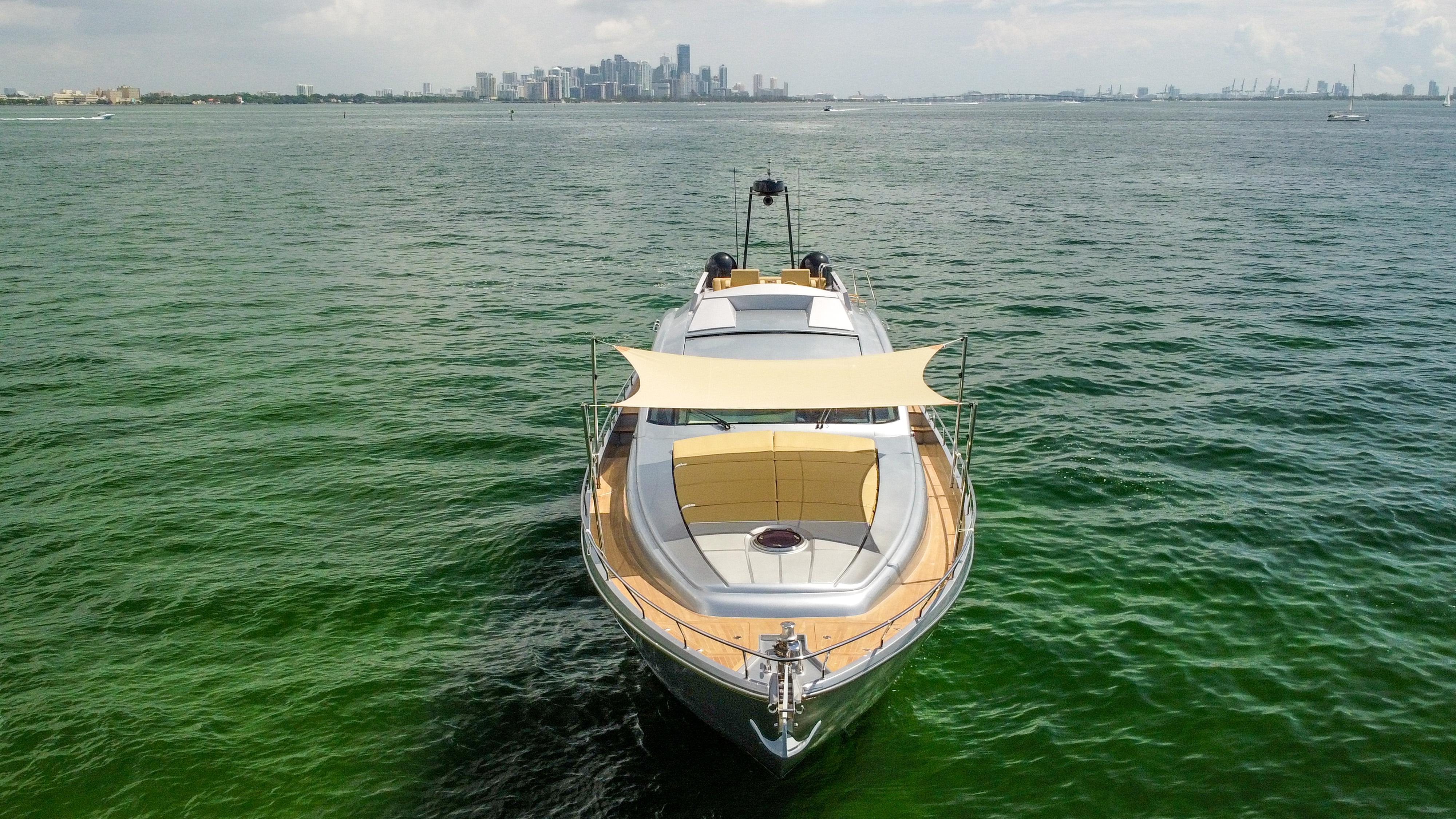 2009 Pershing 72 yacht on open water with city skyline in background.