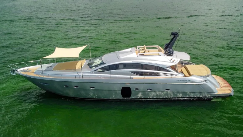  Yacht Photos Pics 2009 Pershing 72 yacht on calm green water, featuring sleek design and sunshade.