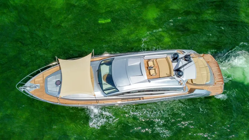  Yacht Photos Pics Aerial view of a 2009 Pershing 72 yacht cruising on vibrant green water.