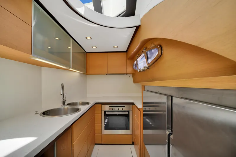  Yacht Photos Pics Modern kitchen interior on 2009 Pershing 72 yacht, featuring sleek wood cabinetry and stainless steel appliances.