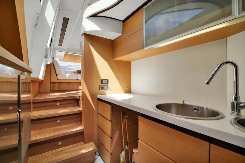  Yacht Photos Pics Luxurious interior of a 2009 Pershing 72 yacht featuring a modern kitchen and wooden stairs.