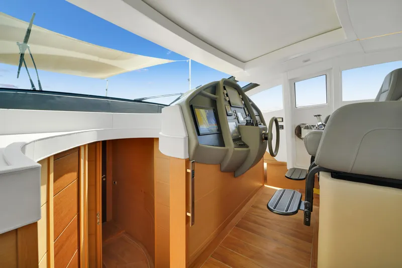  Yacht Photos Pics Interior view of 2009 Pershing 72 yacht cockpit with modern controls and wooden flooring.