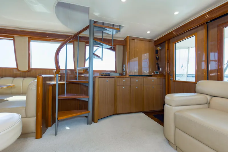 Reel Blues Yacht Photos Pics Luxurious interior of 2007 Viking 64 Enclosed Bridge yacht with spiral staircase and leather seating.