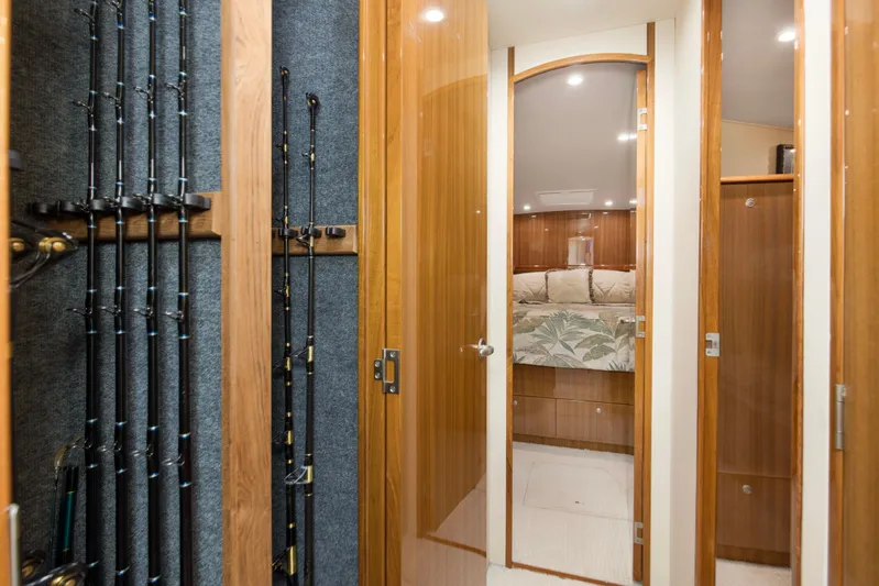 Reel Blues Yacht Photos Pics Luxurious interior of 2007 Viking 64 Enclosed Bridge yacht with fishing rods and cozy bedroom.