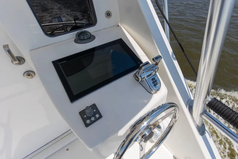 Reel Blues Yacht Photos Pics Control panel of 2007 Viking 64 Enclosed Bridge yacht with steering wheel and touchscreen.