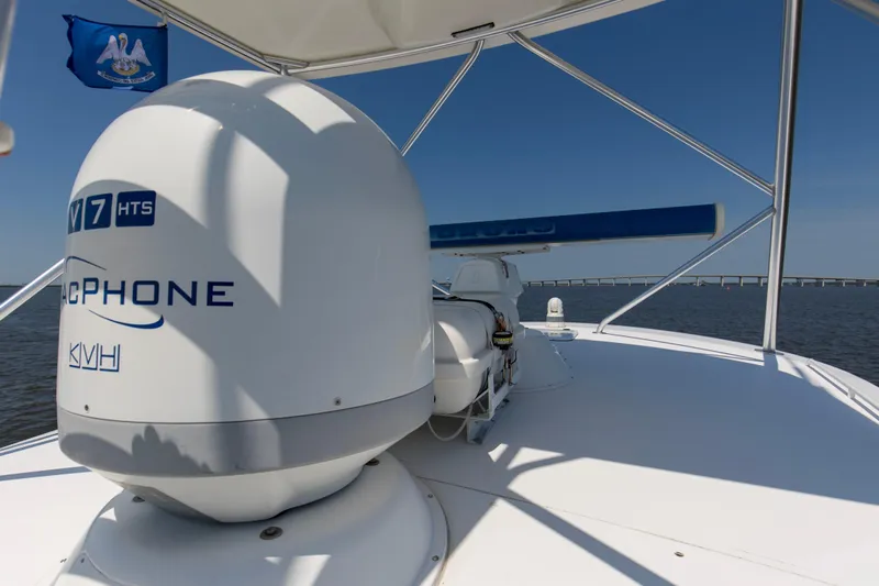 Reel Blues Yacht Photos Pics 2007 Viking 64 Enclosed Bridge yacht with satellite equipment and flag, on open water.