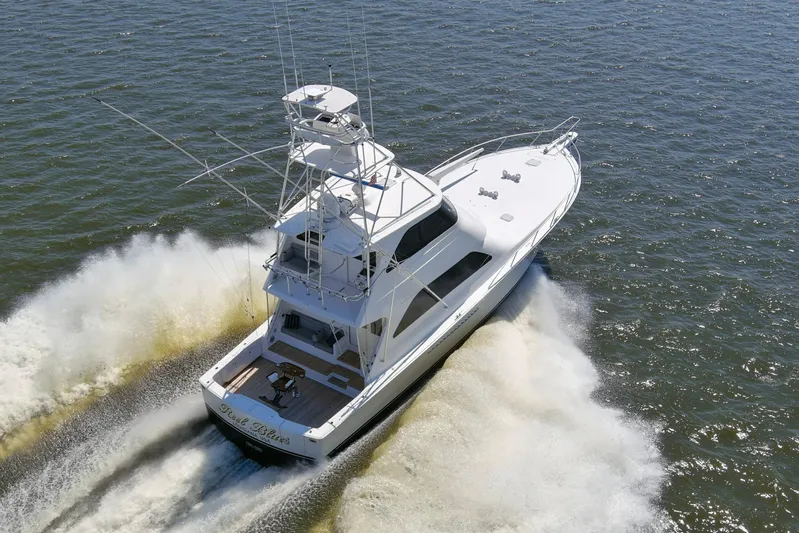 Reel Blues Yacht Photos Pics 2007 Viking 64 Enclosed Bridge yacht cruising on open water, aerial view.