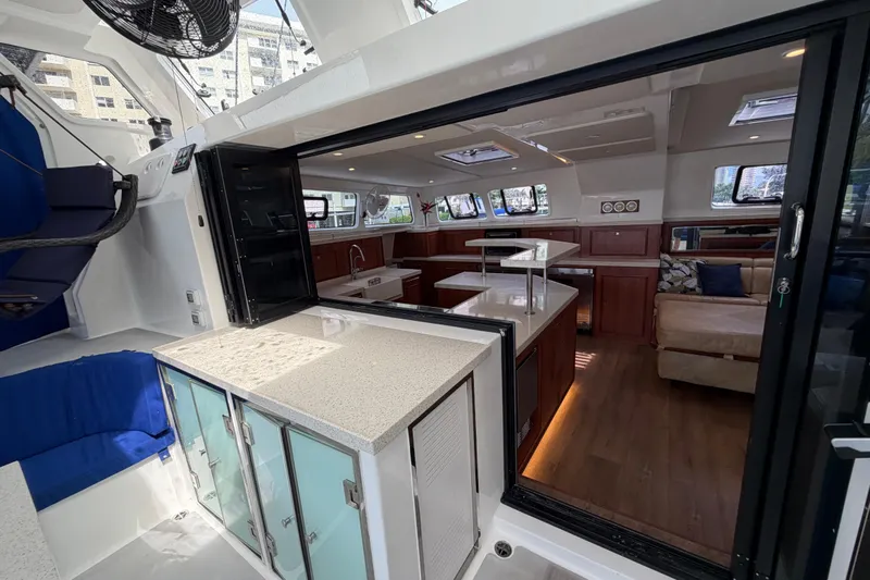 Calacoto Yacht Photos Pics Luxurious interior of 2023 Royal Cape Catamarans Majestic 530, featuring modern kitchen and seating area.