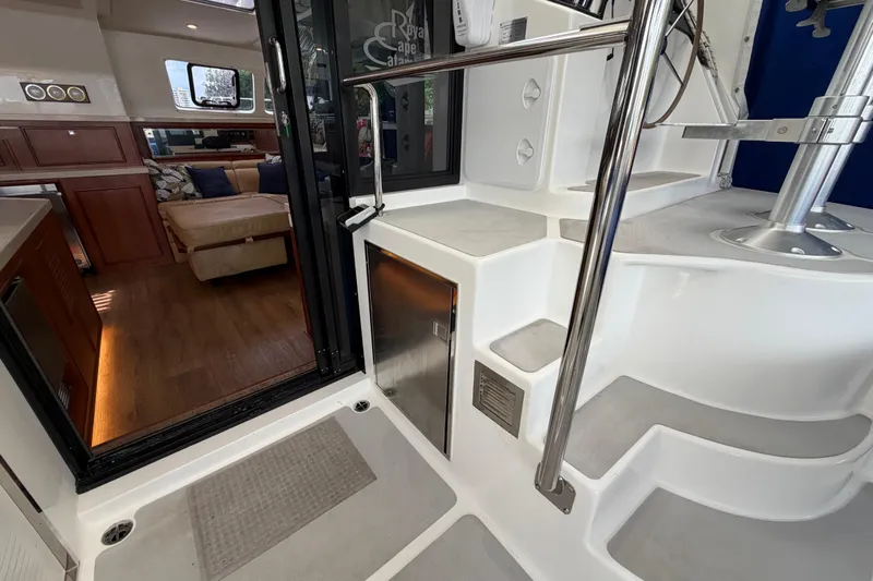 Calacoto Yacht Photos Pics Interior view of 2023 Royal Cape Catamarans Majestic 530, featuring modern staircase and cozy seating area.