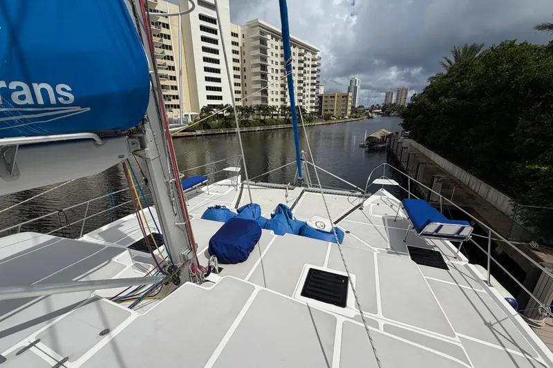 Calacoto Yacht Photos Pics 2023 Royal Cape Catamarans Majestic 530 docked near waterfront buildings under cloudy sky.