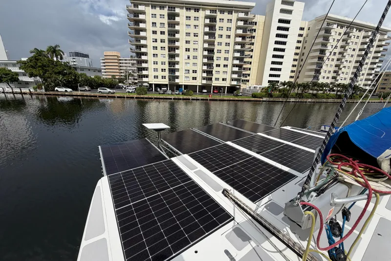 Calacoto Yacht Photos Pics 2023 Royal Cape Catamarans Majestic 530 with solar panels docked near waterfront buildings.