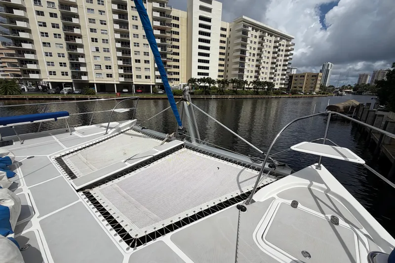 Calacoto Yacht Photos Pics 2023 Royal Cape Catamarans Majestic 530 docked near waterfront buildings under cloudy sky.