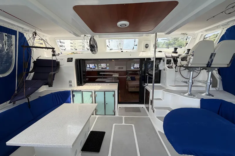 Calacoto Yacht Photos Pics Luxurious interior of 2023 Royal Cape Catamarans Majestic 530 with modern seating and helm station.