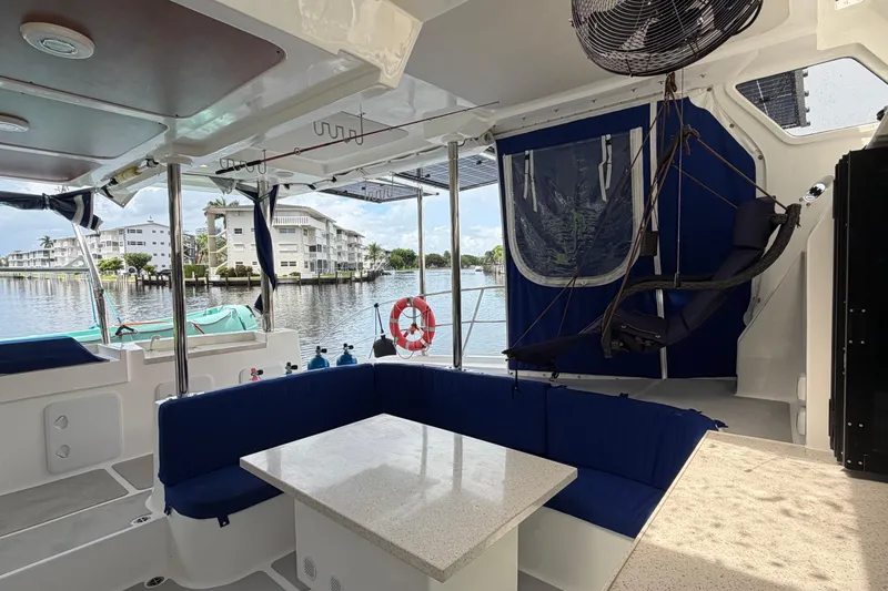 Calacoto Yacht Photos Pics Luxurious 2023 Royal Cape Catamarans Majestic 530 interior with blue seating and waterfront view.