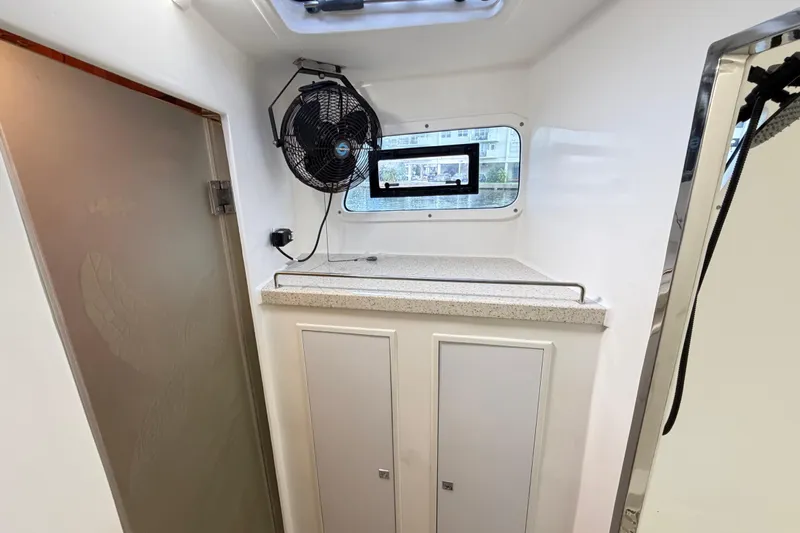 Calacoto Yacht Photos Pics Interior of 2023 Royal Cape Catamarans Majestic 530, featuring a fan and storage cabinets.