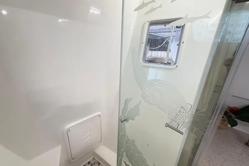 Calacoto Yacht Photos Pics Interior of 2023 Royal Cape Catamarans Majestic 530, featuring a stylish bathroom with etched glass.