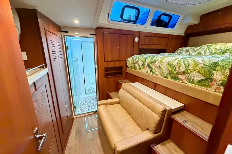 Calacoto Yacht Photos Pics Luxurious interior of 2023 Royal Cape Catamarans Majestic 530 with bed, sofa, and bathroom.