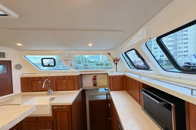 Calacoto Yacht Photos Pics Luxurious interior of 2023 Royal Cape Catamarans Majestic 530 with modern kitchen design.