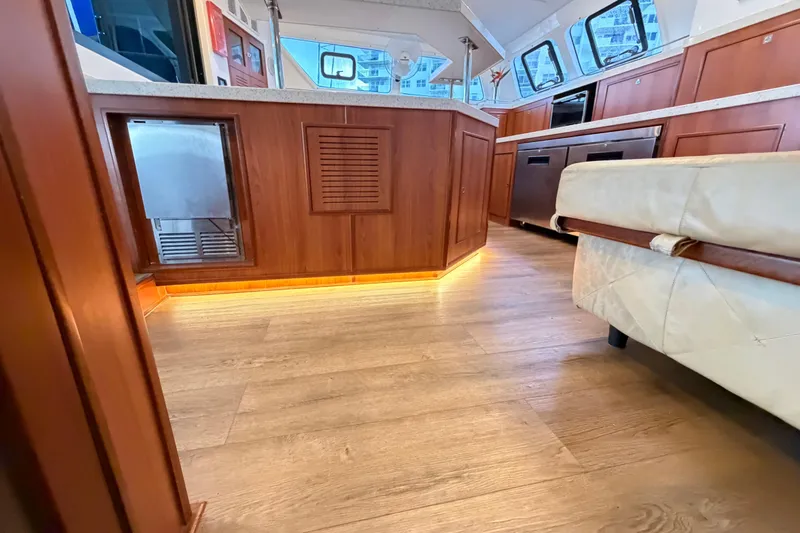 Calacoto Yacht Photos Pics Luxurious interior of 2023 Royal Cape Catamarans Majestic 530, featuring wood flooring and modern kitchen.