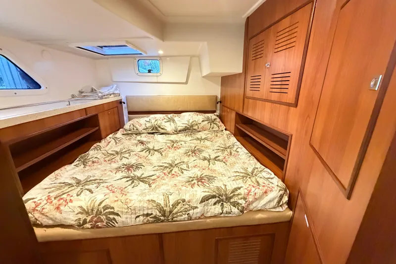 Calacoto Yacht Photos Pics Luxurious cabin interior of 2023 Royal Cape Catamarans Majestic 530 with wood finish and cozy bedding.