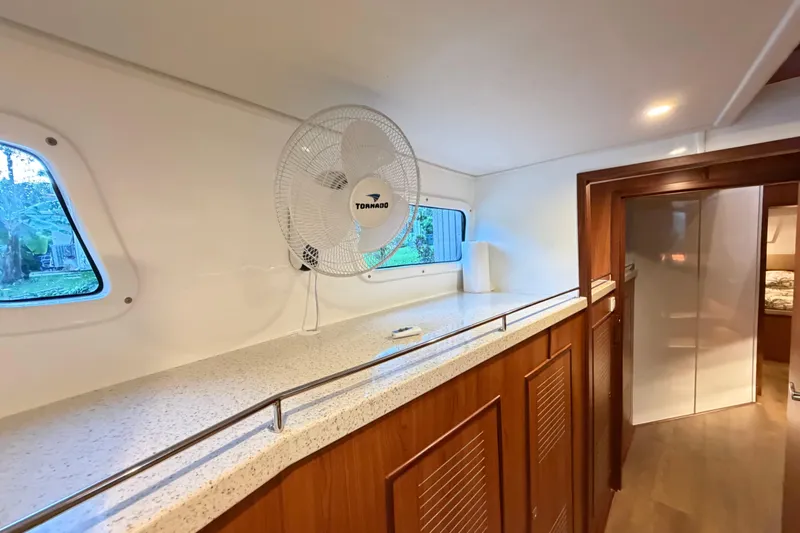 Calacoto Yacht Photos Pics Interior of 2023 Royal Cape Catamarans Majestic 530 with fan and wooden cabinetry.