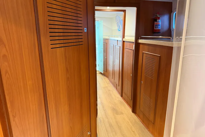 Calacoto Yacht Photos Pics Interior hallway of 2023 Royal Cape Catamarans Majestic 530, featuring wooden cabinetry and flooring.