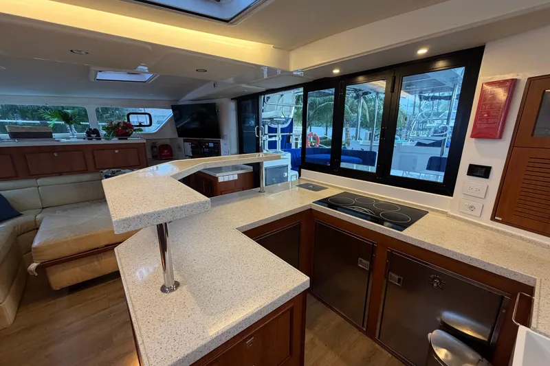 Calacoto Yacht Photos Pics Luxurious interior of 2023 Royal Cape Catamarans Majestic 530 with modern kitchen and seating area.